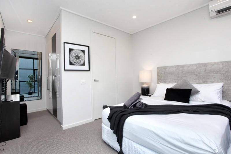 Imagen de dormitorio principal moderno pequeño con paredes grises, moqueta y suelo gris