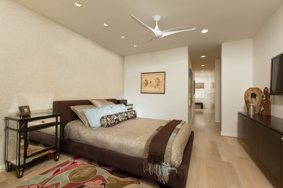 Foto de dormitorio principal actual de tamaño medio sin chimenea con paredes beige y suelo de madera clara