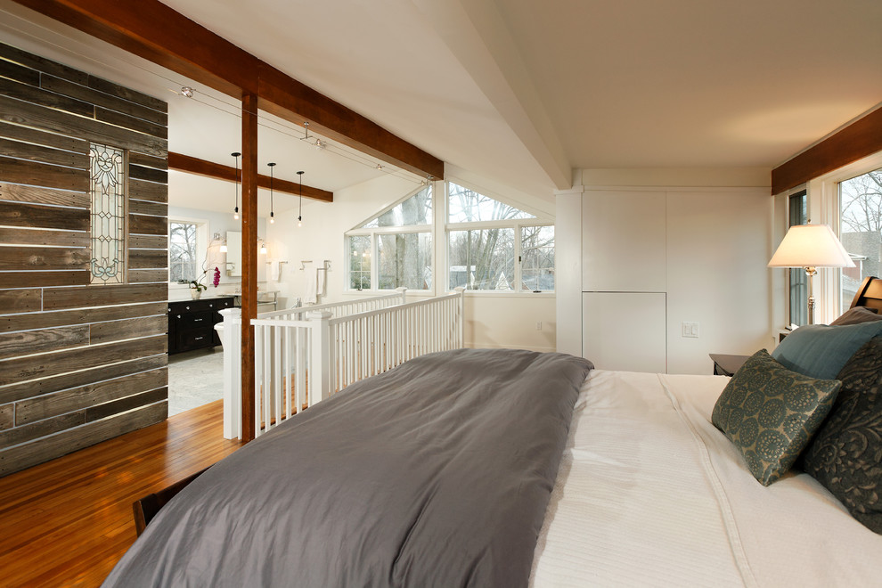 Foto de dormitorio tipo loft tradicional renovado grande sin chimenea con paredes blancas y suelo de madera en tonos medios