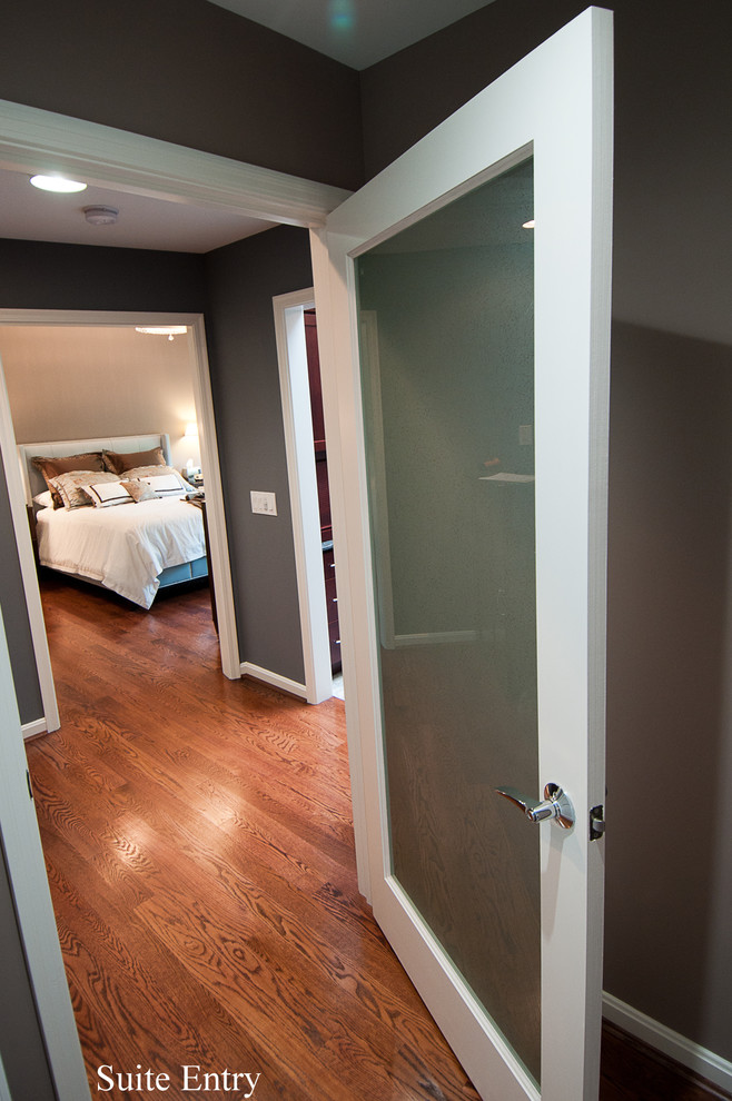 Foto de dormitorio principal tradicional pequeño sin chimenea con paredes grises y suelo de madera en tonos medios
