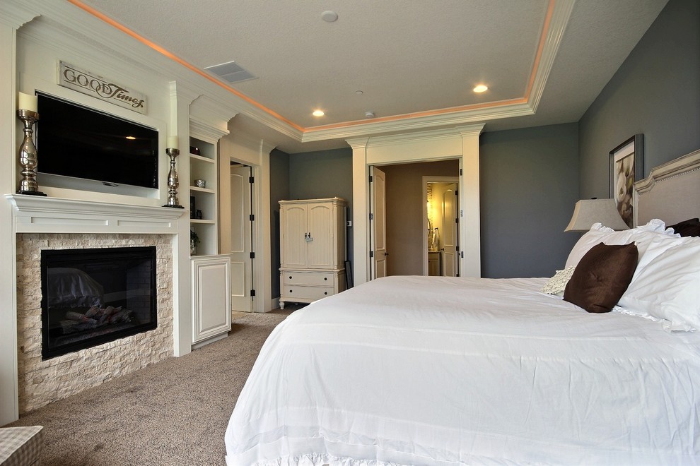 Пример оригинального дизайна: большая хозяйская спальня в стиле неоклассика (современная классика) с синими стенами, ковровым покрытием, стандартным камином и фасадом камина из камня