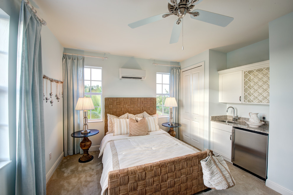 マイアミにある小さなビーチスタイルのおしゃれな主寝室 (青い壁、カーペット敷き、ベージュの床、青いカーテン) のインテリア