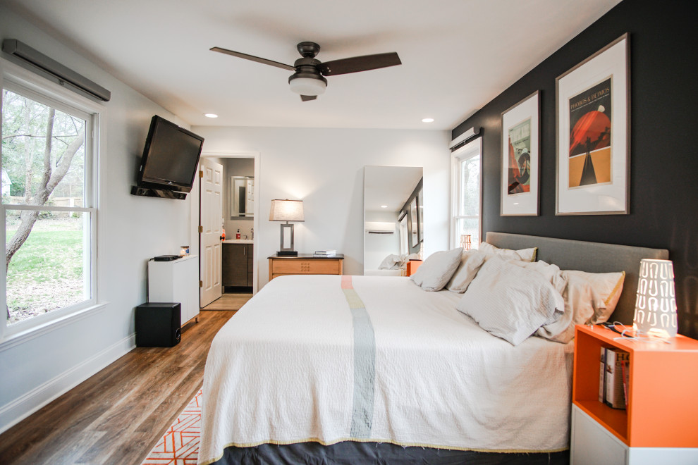 Imagen de dormitorio principal minimalista de tamaño medio sin chimenea con paredes blancas, suelo de madera clara y suelo marrón