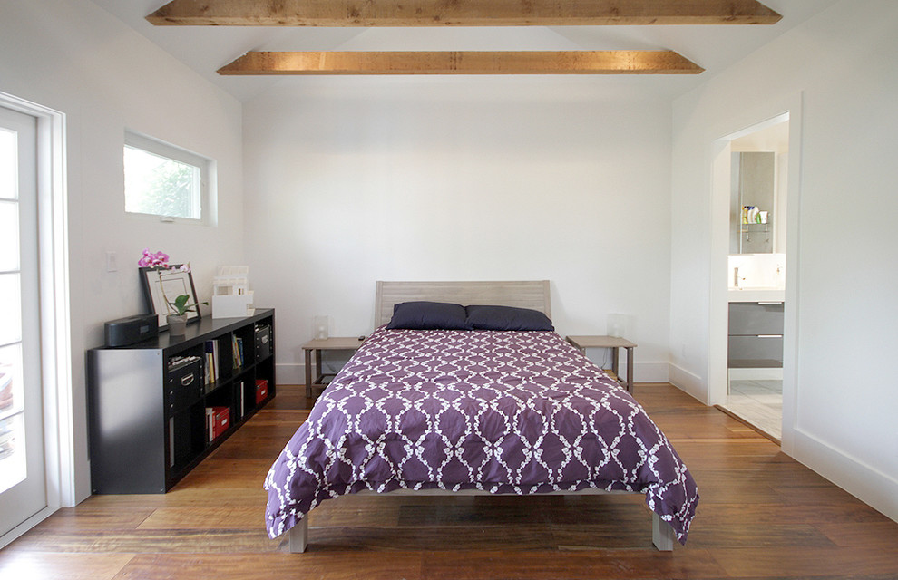 Modernes Schlafzimmer ohne Kamin mit weißer Wandfarbe und braunem Holzboden in Houston