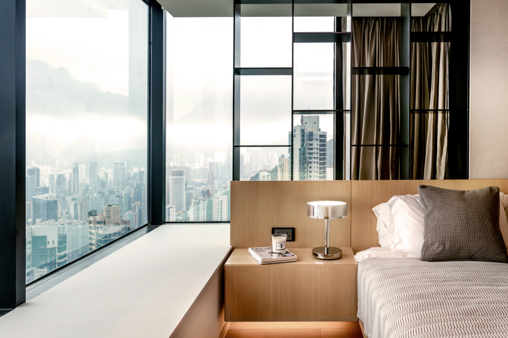 Esempio di una camera da letto design con pareti beige, pavimento in legno massello medio e pavimento marrone