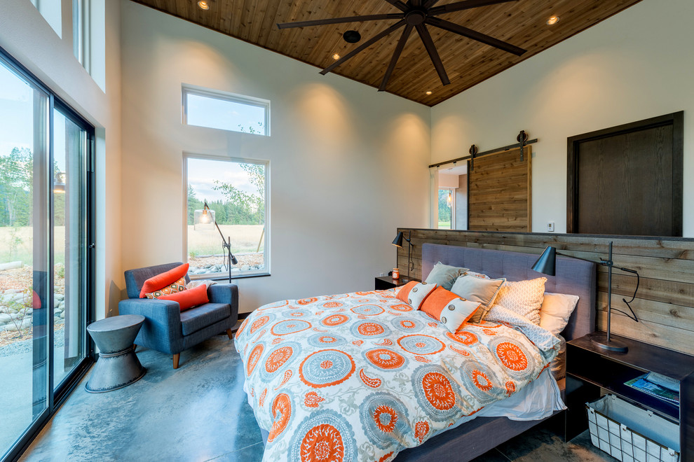 Diseño de dormitorio principal rural grande con paredes blancas, suelo de cemento y suelo beige