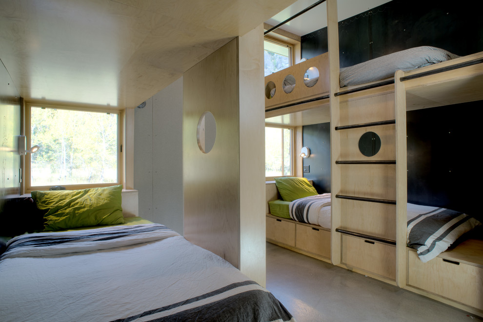 シアトルにある小さなコンテンポラリースタイルのおしゃれな客用寝室 (コンクリートの床、黒い壁、暖炉なし)