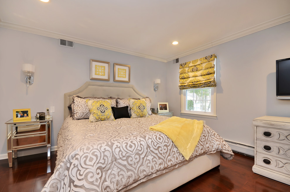 Ejemplo de dormitorio televisión tradicional con paredes grises y suelo de madera en tonos medios