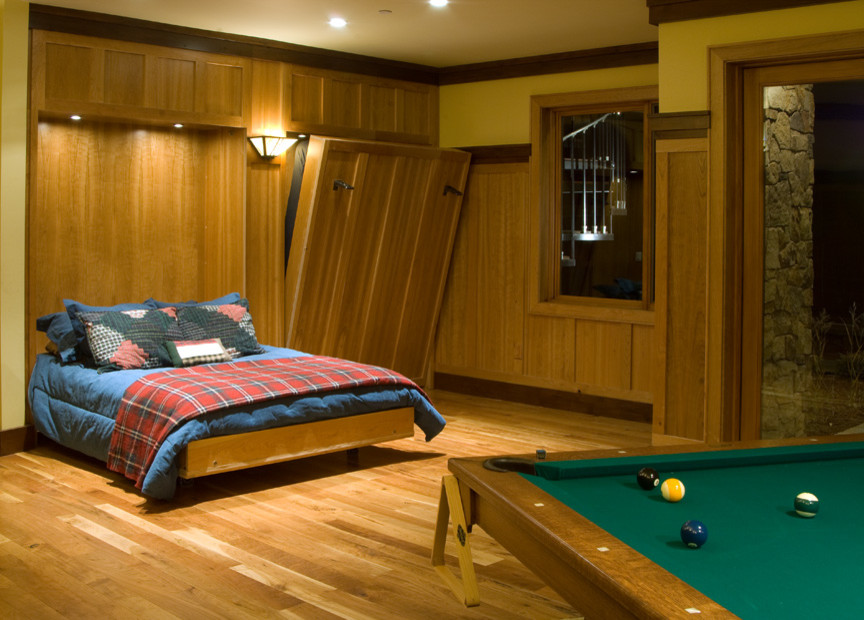 Modelo de habitación de invitados de estilo americano grande sin chimenea con paredes marrones y suelo de madera clara