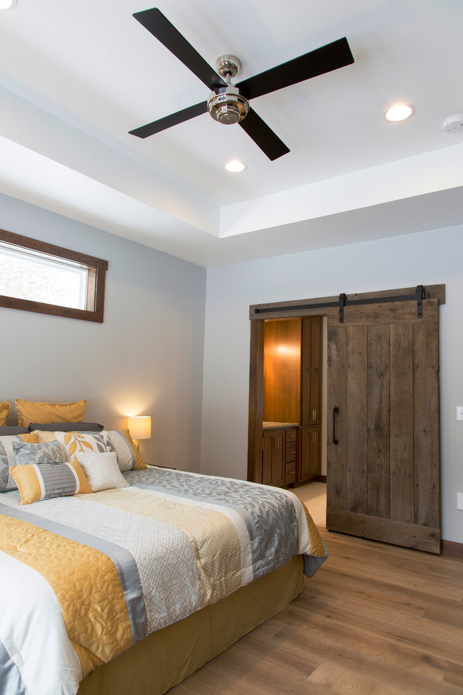 Großes Rustikales Hauptschlafzimmer ohne Kamin mit grauer Wandfarbe und hellem Holzboden in Sonstige