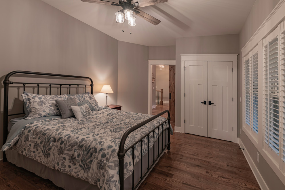 Imagen de dormitorio principal rústico de tamaño medio sin chimenea con paredes beige, suelo de madera en tonos medios y suelo marrón