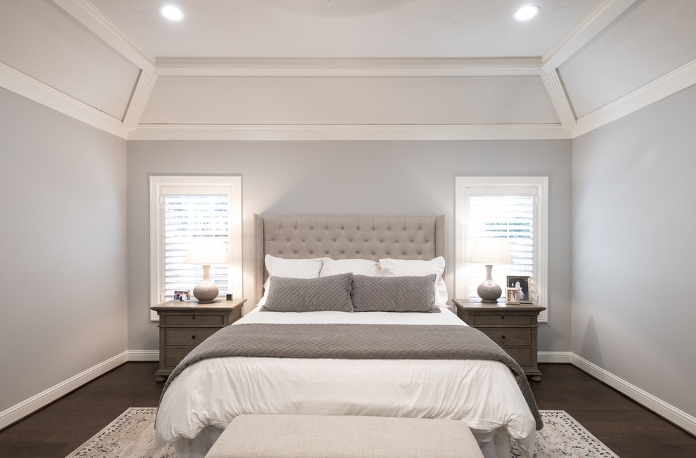 На фото: спальня в стиле неоклассика (современная классика) с серыми стенами, темным паркетным полом и коричневым полом