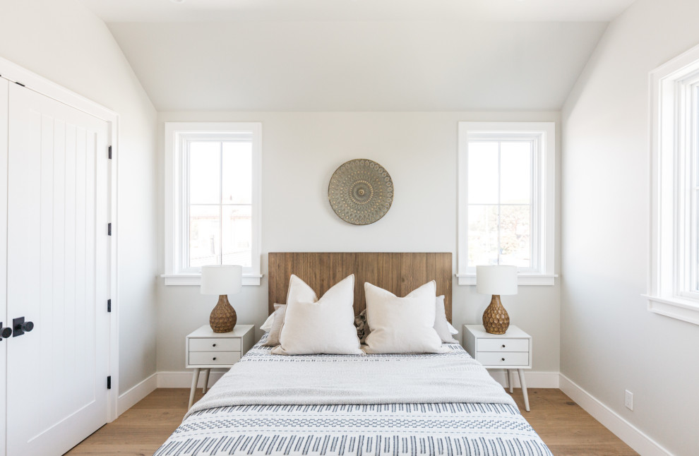 Foto di una camera da letto country con pareti grigie, pavimento in legno massello medio, pavimento marrone e soffitto a volta