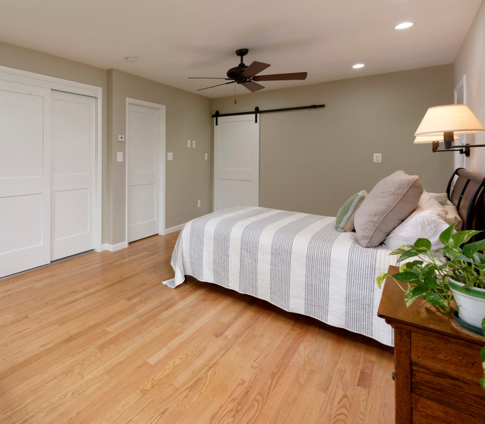 Modelo de dormitorio principal tradicional renovado con paredes beige y suelo de madera en tonos medios