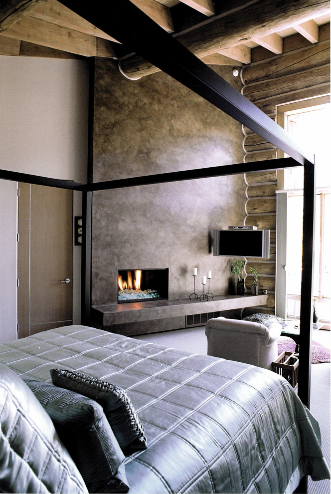 Стильный дизайн: хозяйская спальня среднего размера в стиле модернизм с бежевыми стенами, ковровым покрытием, стандартным камином и фасадом камина из бетона - последний тренд