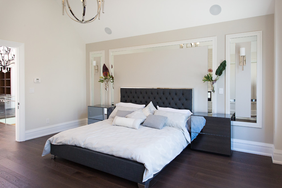 Пример оригинального дизайна: большая хозяйская спальня в стиле неоклассика (современная классика) с бежевыми стенами, темным паркетным полом, стандартным камином, фасадом камина из штукатурки и коричневым полом