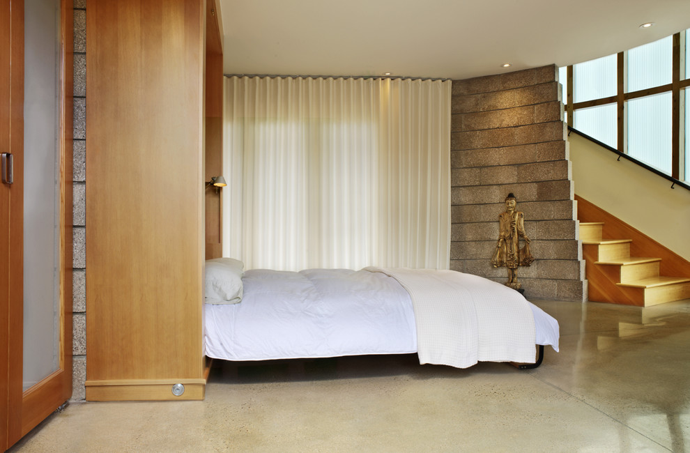 Inspiration for a contemporary concrete floor bedroom remodel in Denver with beige walls