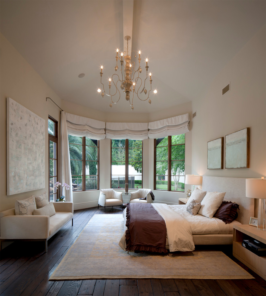 Design ideas for a large mediterranean master bedroom in Houston with beige walls and dark hardwood flooring.