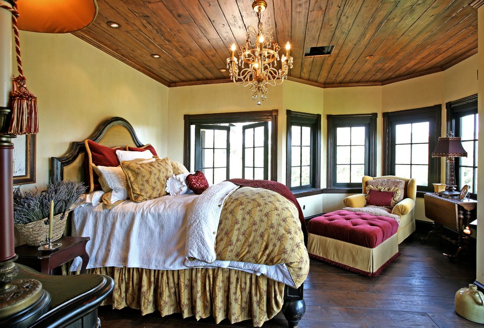 Ejemplo de dormitorio mediterráneo con paredes beige y suelo de madera oscura