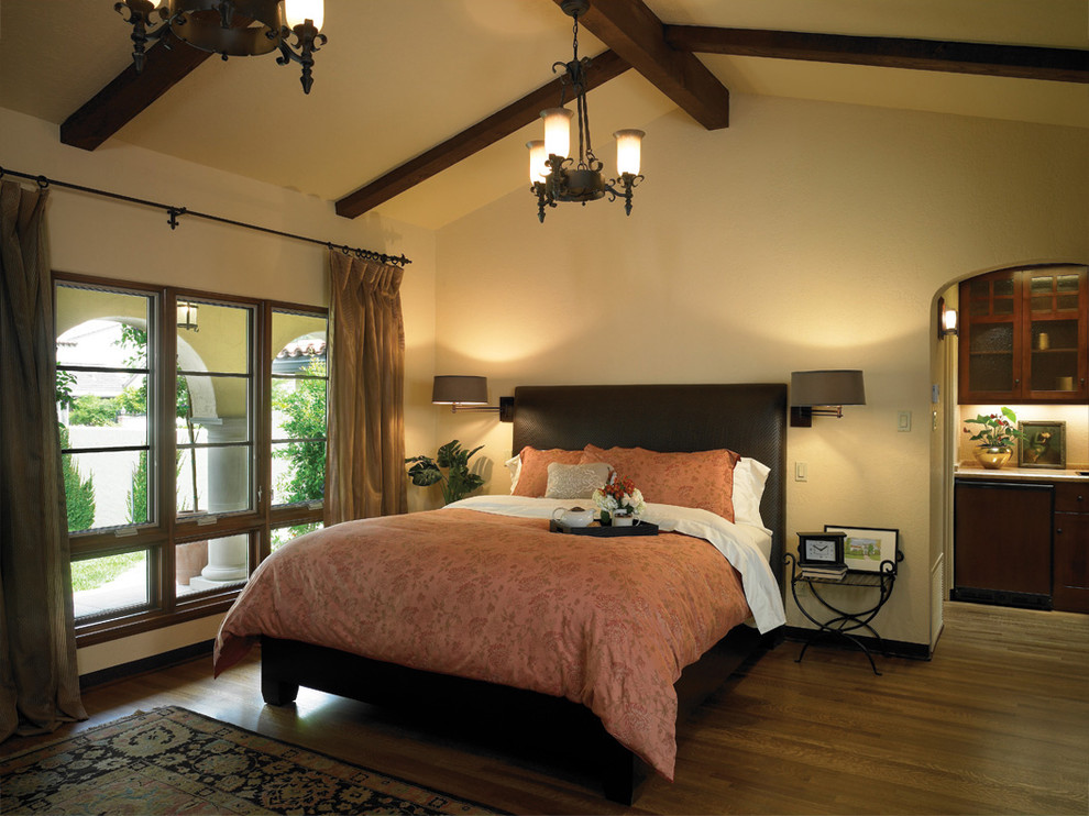 Mediterranes Schlafzimmer mit beiger Wandfarbe und dunklem Holzboden in Los Angeles