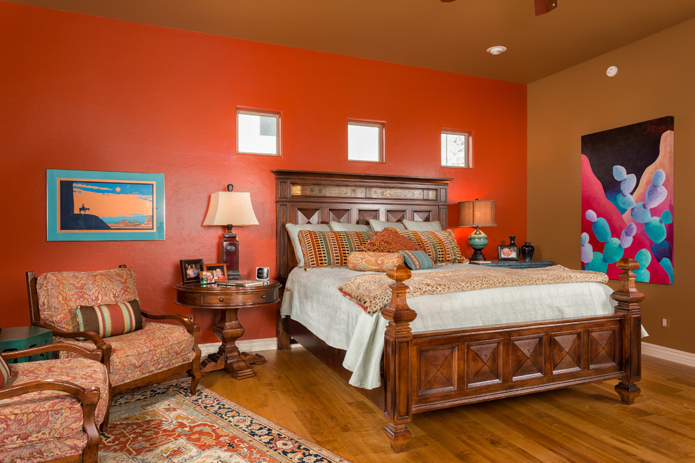 Diseño de dormitorio principal mediterráneo con paredes rojas y suelo de madera en tonos medios