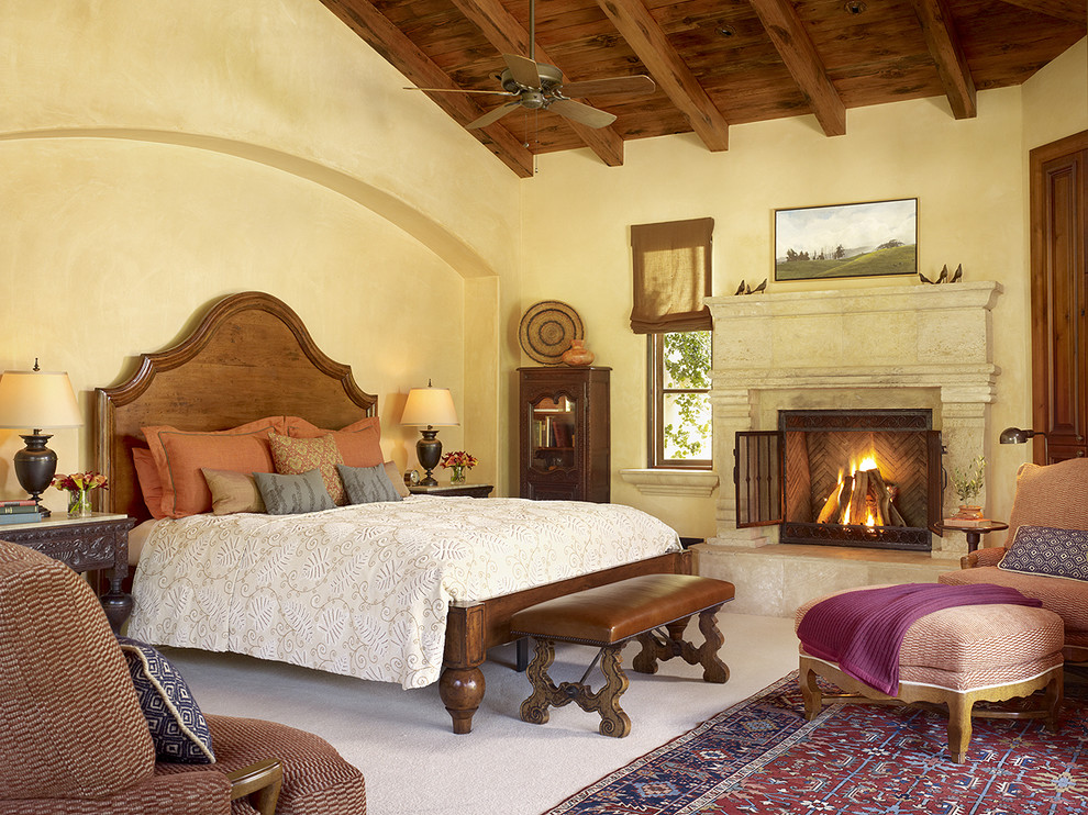 サンフランシスコにある地中海スタイルのおしゃれな寝室 (黄色い壁、カーペット敷き、標準型暖炉) のインテリア