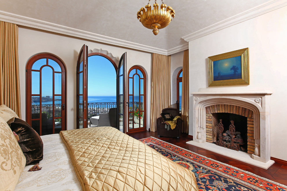 Стильный дизайн: спальня в средиземноморском стиле с стандартным камином и фасадом камина из кирпича - последний тренд