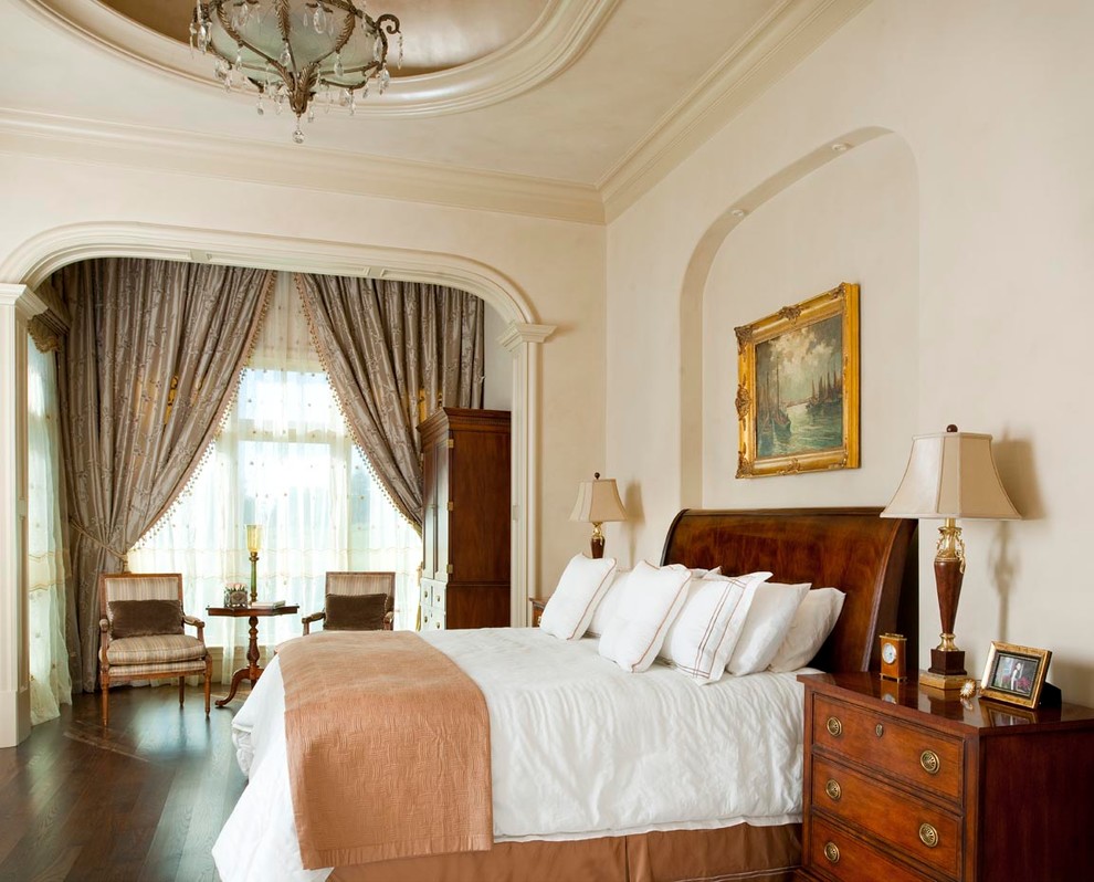 Mediterranes Schlafzimmer mit beiger Wandfarbe und dunklem Holzboden in Dallas