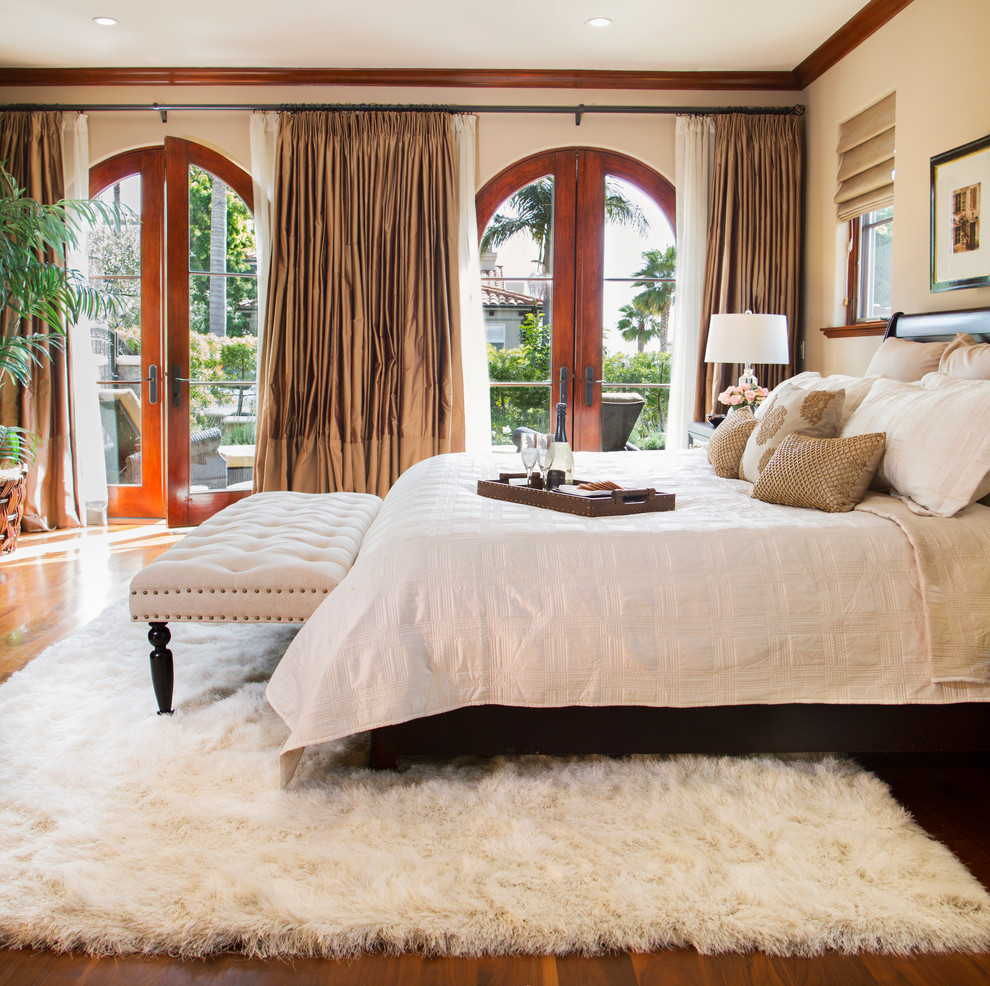 Bedroom - mediterranean master medium tone wood floor and brown floor bedroom idea in Los Angeles with white walls