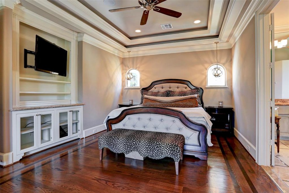 This is an example of a large mediterranean master bedroom in Houston with grey walls, dark hardwood flooring and brown floors.
