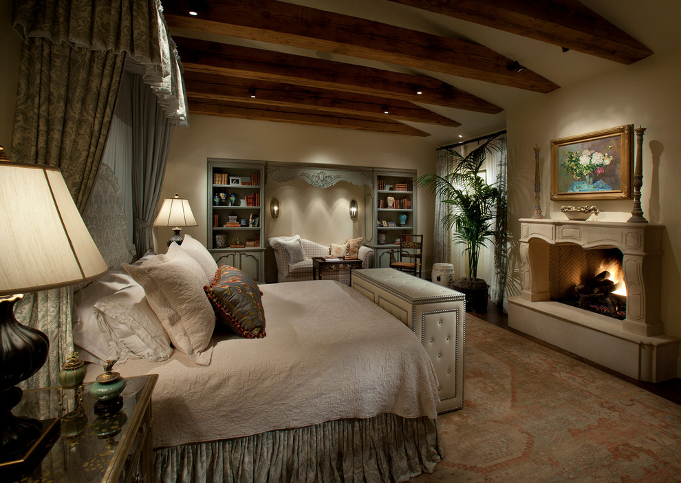 Großes Mediterranes Hauptschlafzimmer mit beiger Wandfarbe, dunklem Holzboden, Kamin und Kaminumrandung aus Stein in Phoenix