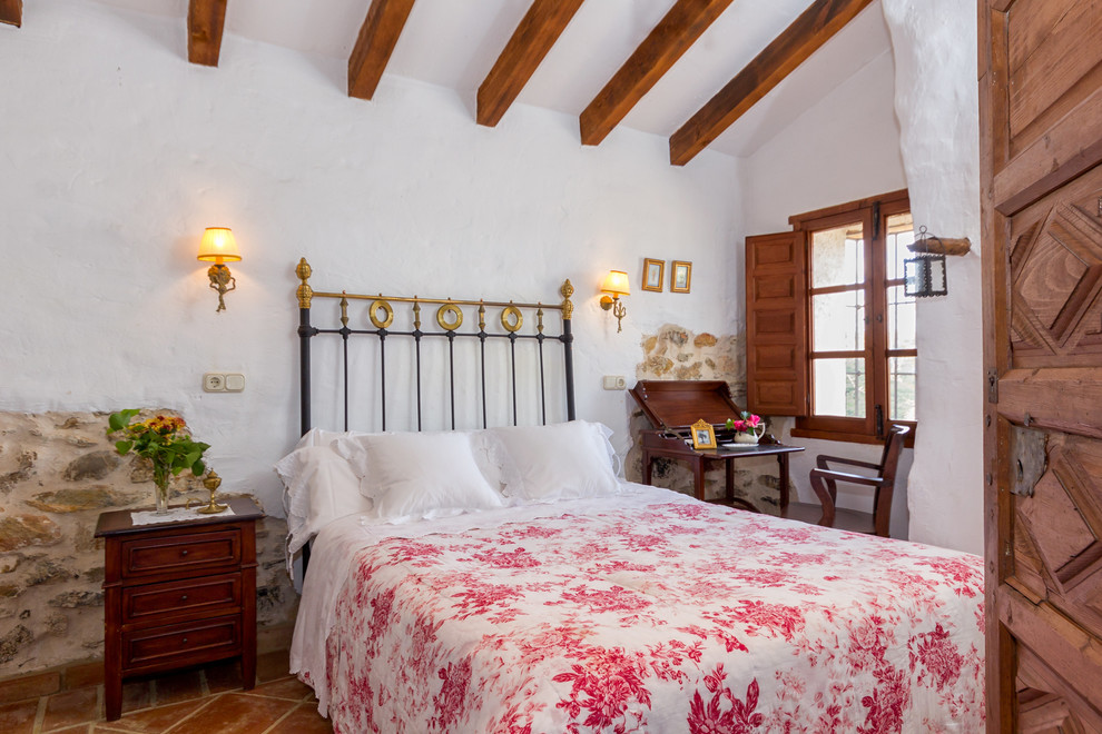 На фото: хозяйская спальня среднего размера в средиземноморском стиле с белыми стенами и полом из терракотовой плитки без камина с