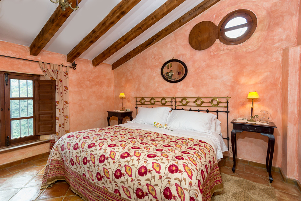 This is an example of a medium sized mediterranean master bedroom in Malaga with orange walls, terracotta flooring and no fireplace.