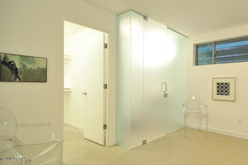 Пример оригинального дизайна: хозяйская спальня в стиле модернизм с белыми стенами, бетонным полом и серым полом