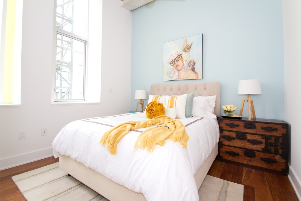 Ispirazione per una camera da letto minimal con pareti blu e pavimento in legno massello medio