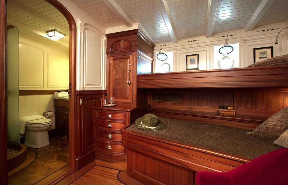 Modelo de dormitorio tradicional pequeño con paredes blancas y suelo de madera en tonos medios
