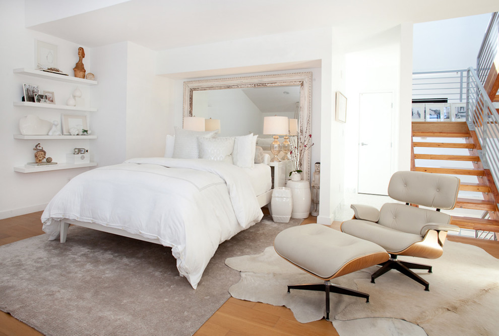 Modelo de dormitorio tipo loft tradicional renovado con paredes blancas y suelo de madera en tonos medios