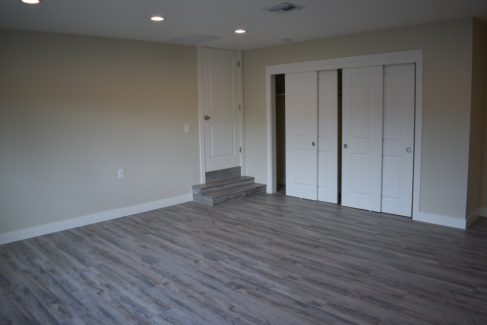Immagine di una camera matrimoniale minimalista di medie dimensioni con pareti beige, pavimento in vinile e pavimento grigio