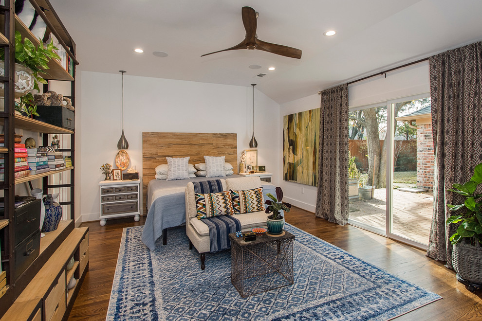 Example of a large eclectic master medium tone wood floor bedroom design in Dallas with white walls