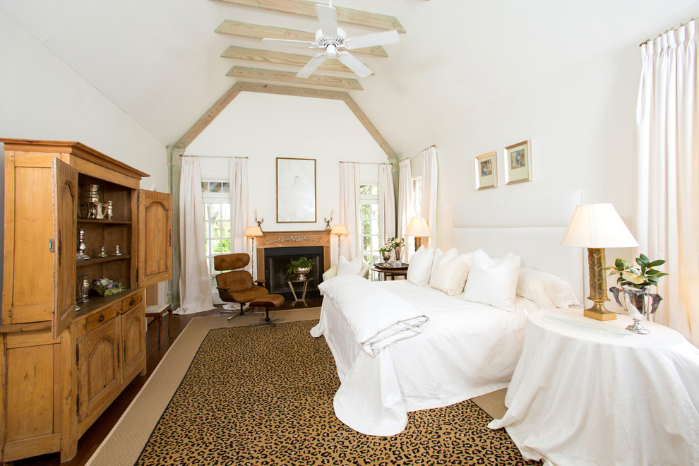 Пример оригинального дизайна: спальня в классическом стиле с белыми стенами, темным паркетным полом и стандартным камином