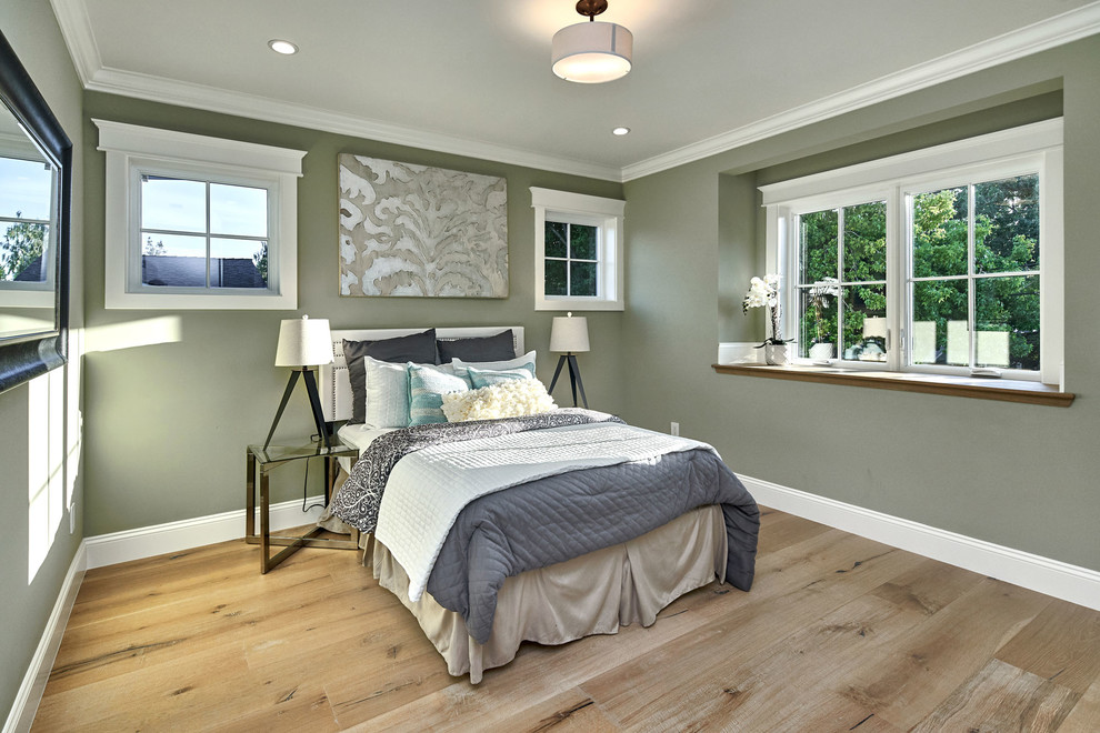 This is an example of a medium sized farmhouse guest bedroom in San Francisco with green walls, light hardwood flooring and grey floors.