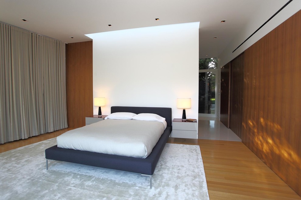 Modernes Schlafzimmer ohne Kamin mit weißer Wandfarbe und braunem Holzboden in San Francisco