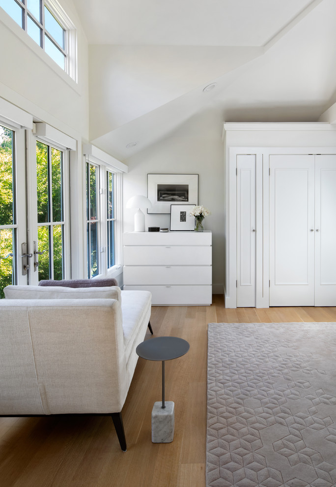 Cette image montre une petite chambre parentale design avec un mur blanc, parquet clair et un sol beige.