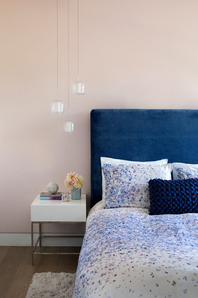 На фото: спальня в современном стиле с розовыми стенами и светлым паркетным полом