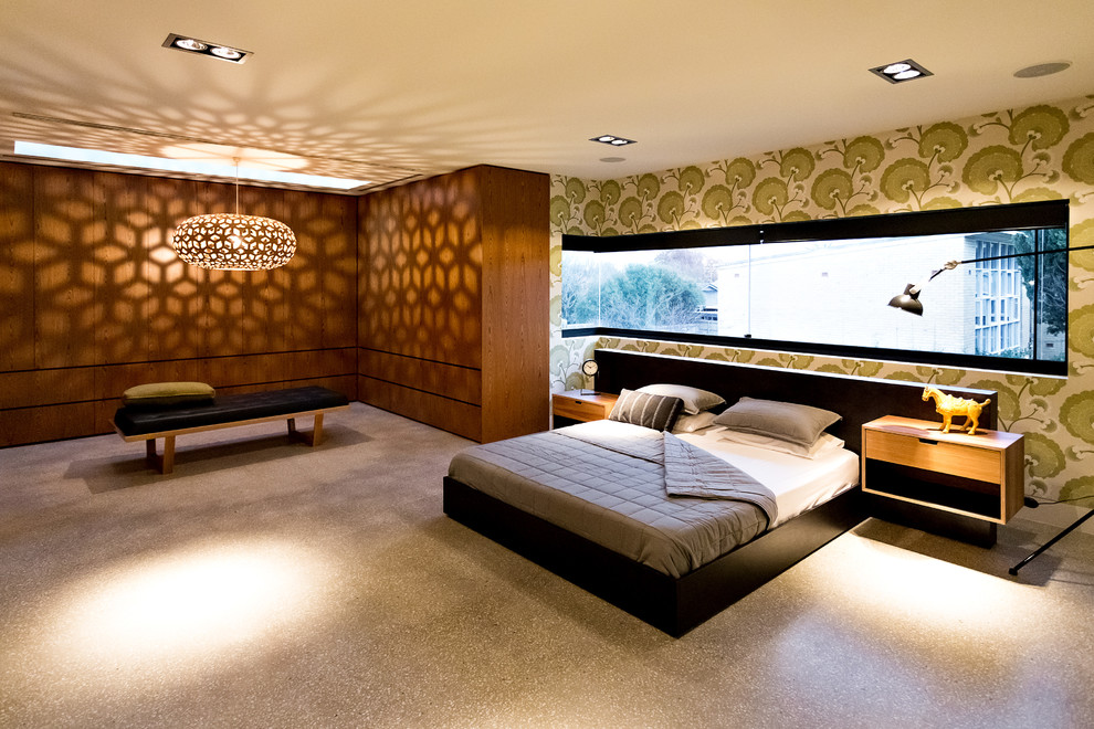 Inredning av ett modernt stort sovrum, med flerfärgade väggar och betonggolv