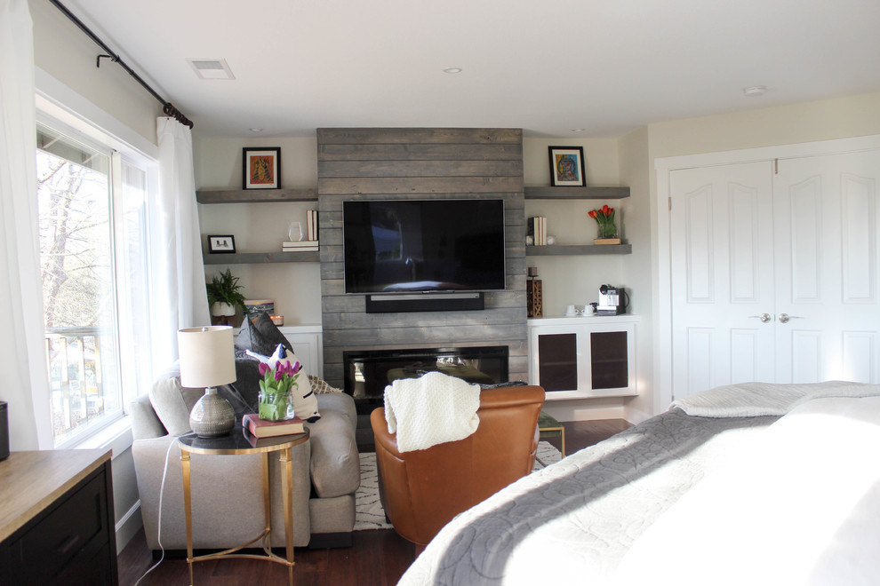 Mittelgroßes Modernes Hauptschlafzimmer mit grauer Wandfarbe, dunklem Holzboden, Hängekamin, Kaminumrandung aus Holz und braunem Boden in Sonstige