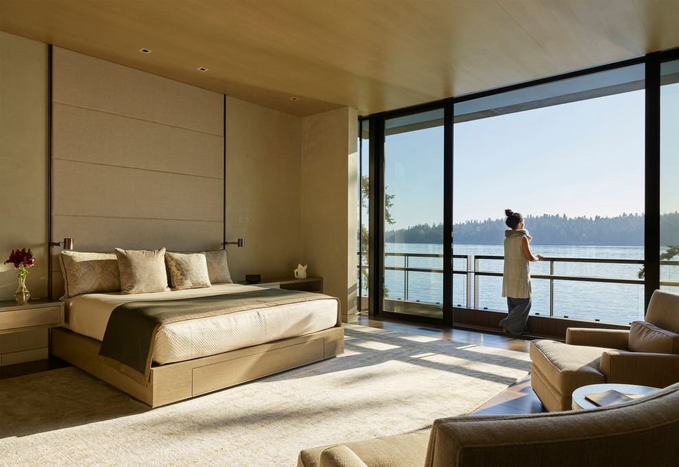 Esempio di una camera da letto contemporanea con pareti beige, pavimento in legno massello medio e pavimento marrone