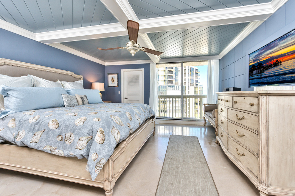 Foto de dormitorio principal costero grande sin chimenea con paredes azules y suelo de baldosas de porcelana