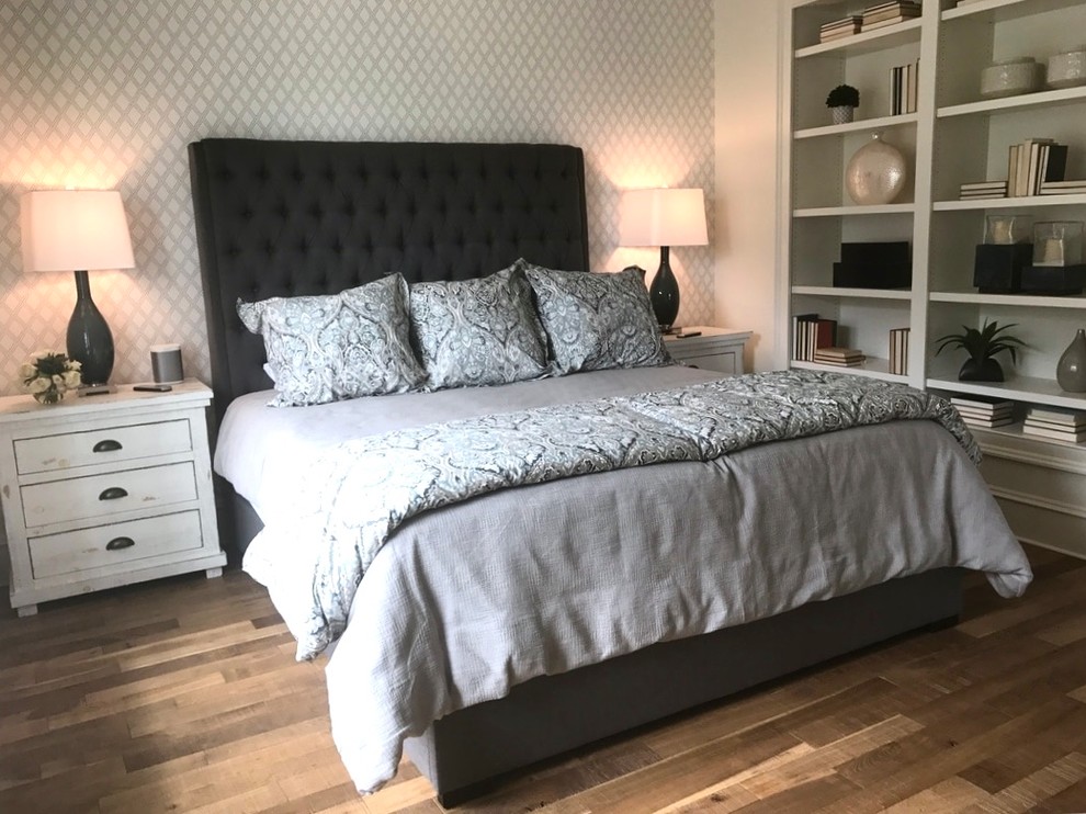 Imagen de dormitorio principal clásico renovado con paredes blancas, suelo de madera en tonos medios y suelo marrón
