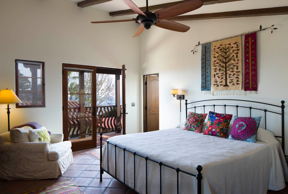 Mediterranes Schlafzimmer mit weißer Wandfarbe, Terrakottaboden, rotem Boden und freigelegten Dachbalken in Santa Barbara